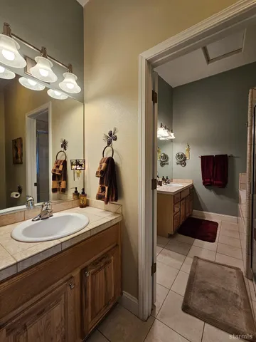 a en suite bathroom with a double vanity sink and a mirror