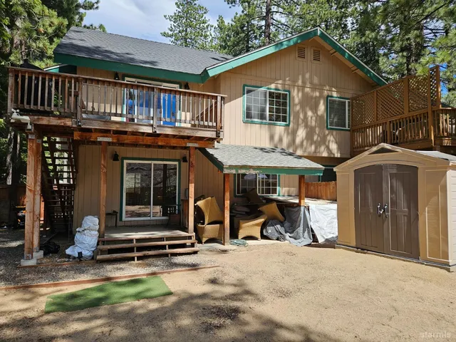 a view of a house with wooden walls and a yard