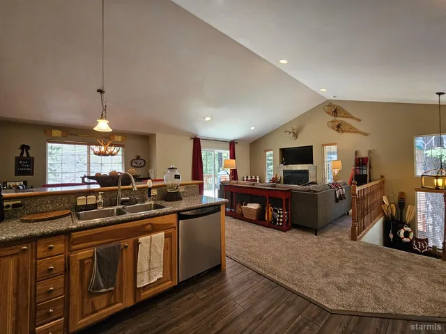 a large kitchen with stainless steel appliances a large counter top a stove and a sink