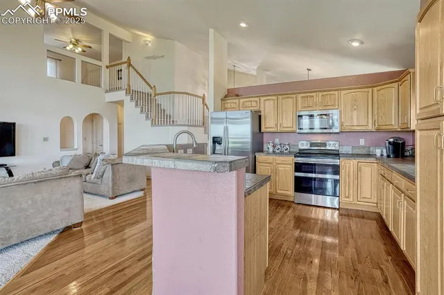 a kitchen with stainless steel appliances granite countertop a refrigerator and a stove top oven