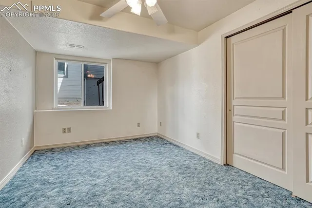 a spacious bedroom with a bed and a flat screen tv