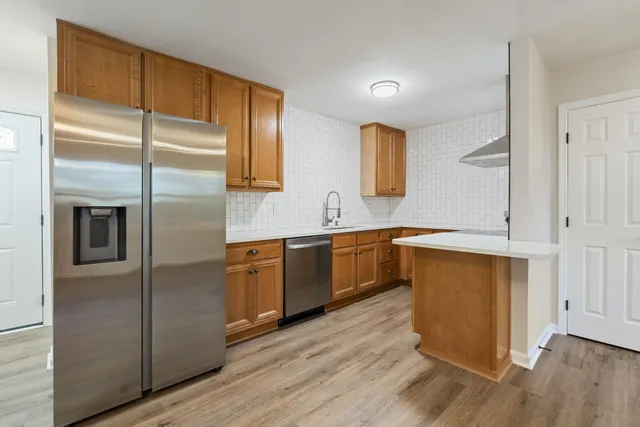 a kitchen with a refrigerator sink and cabinets