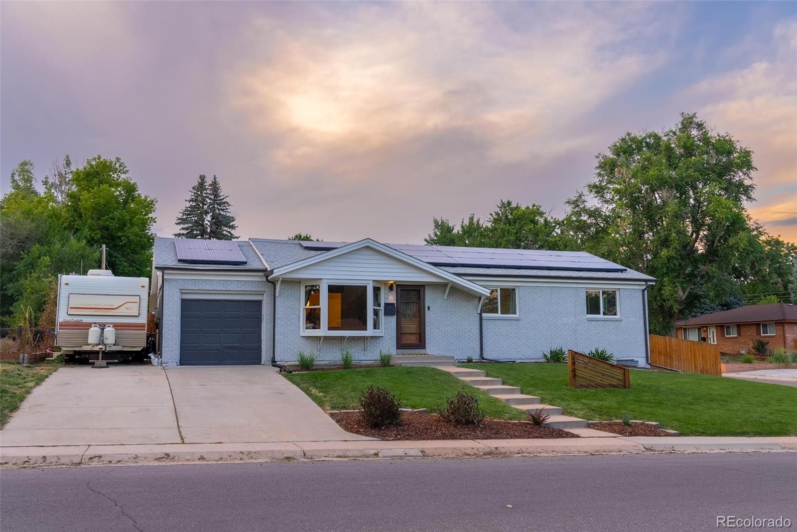 4947 South Perry Street Littleton, CO 80123 - Photo 1 of 24 a front view of a house with a garden and trees
