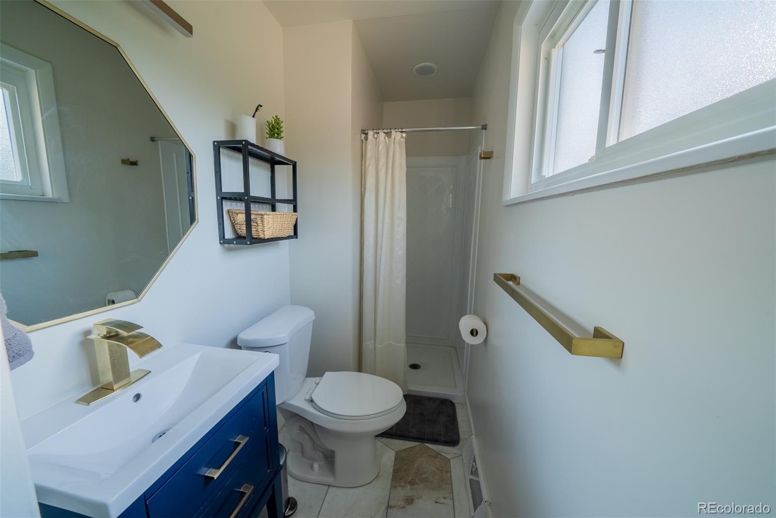 4947 South Perry Street Littleton, CO 80123 - Photo 8 of 24 a bathroom with a toilet sink and mirror
