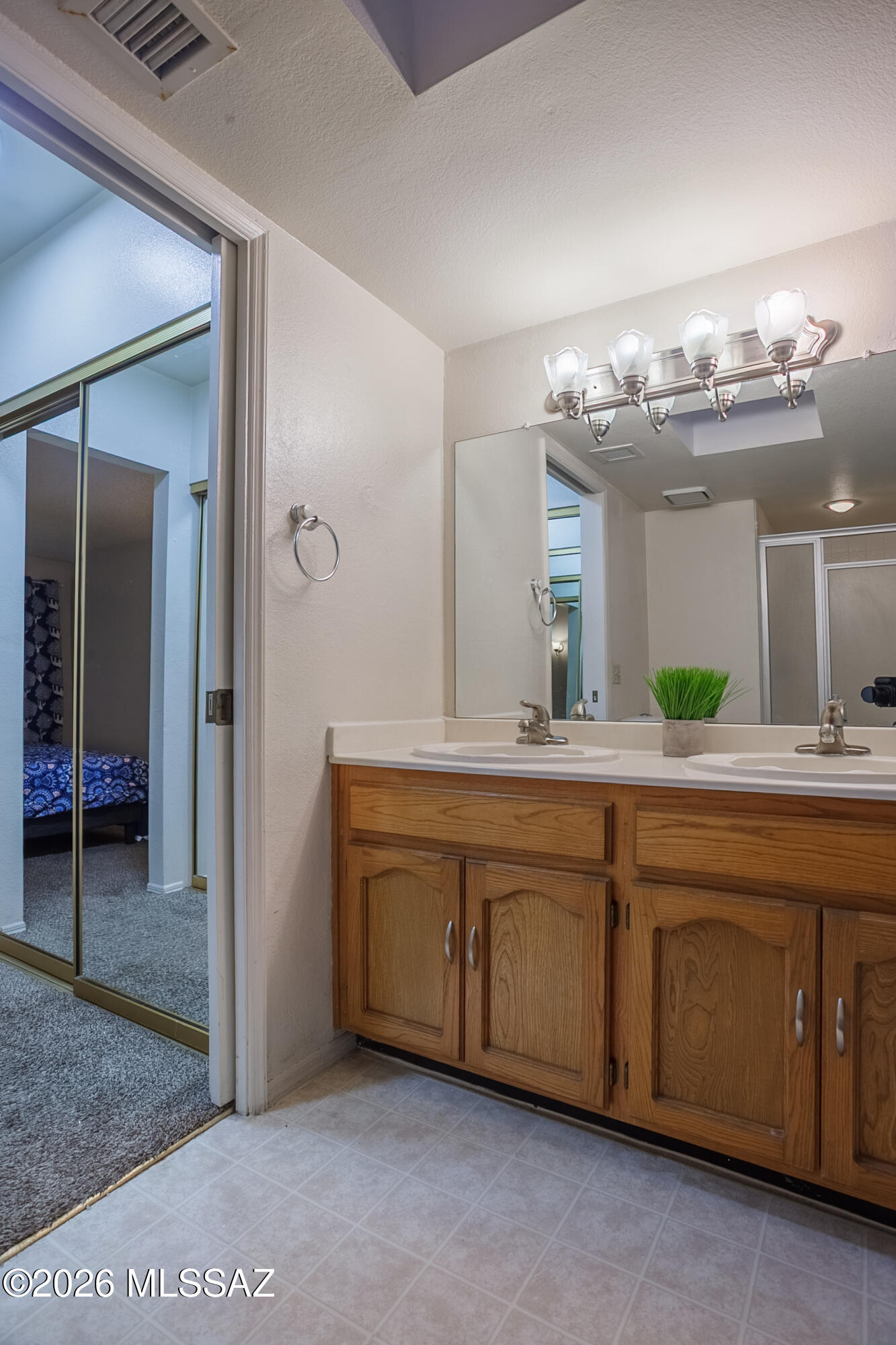 1200 East River Road, Unit B27 Tucson, AZ 85718 - Photo 30 of 40 a bathroom with a double vanity sink and a mirror