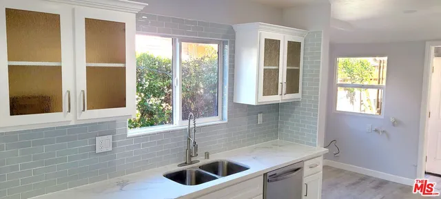 a view of a kitchen with a sink window and cabinets