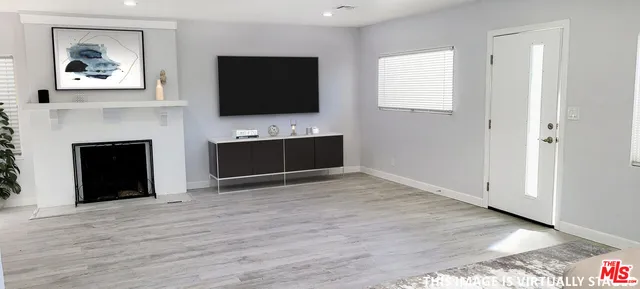 an empty room with windows fireplace and cabinet