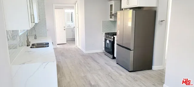 a view of a refrigerator in kitchen and wooden floor