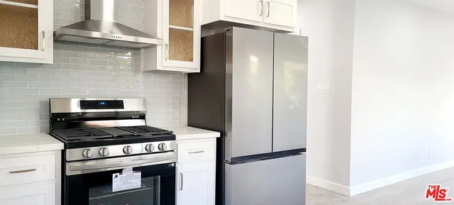 a kitchen with stainless steel appliances granite countertop white cabinets and a stove