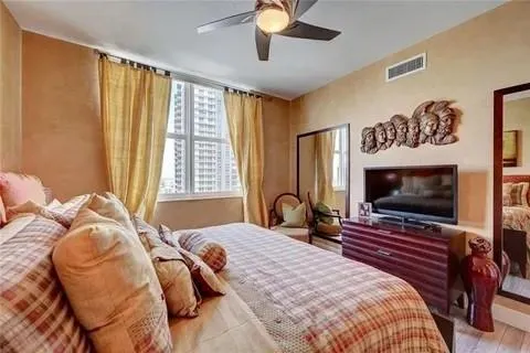 a bedroom with a bed and a flat screen tv