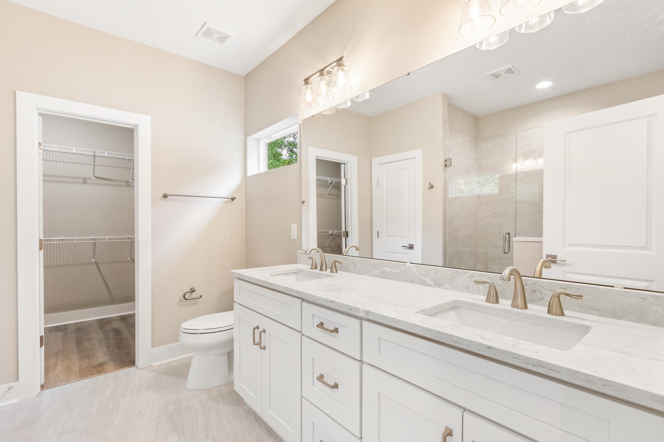 6334 Salado Road St. Augustine, FL 32080 - Photo 18 of 37 a spacious bathroom with a granite countertop sink a toilet a mirror and shower