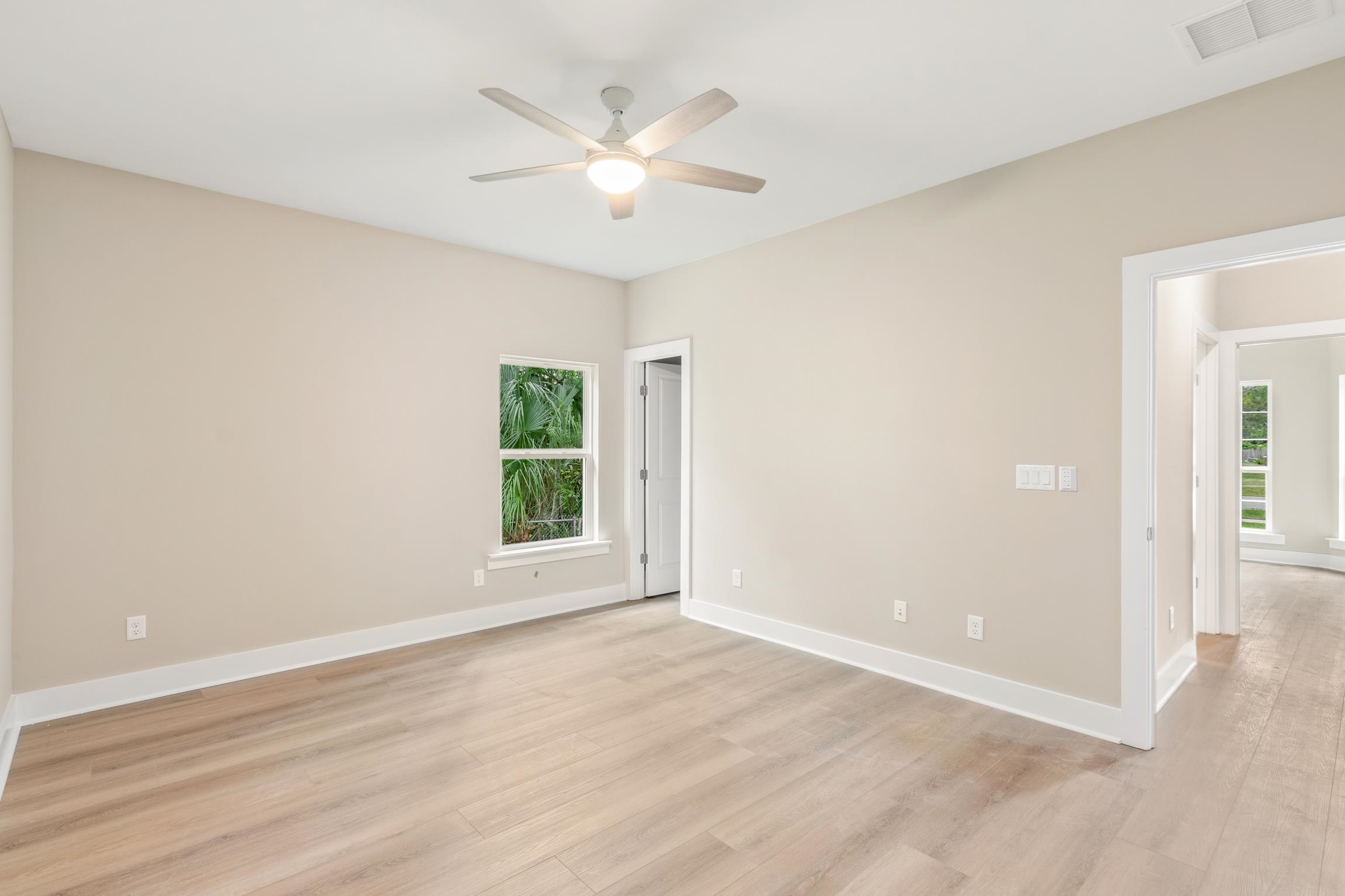 6334 Salado Road St. Augustine, FL 32080 - Photo 25 of 37 an empty room with wooden floor ceiling fan and windows