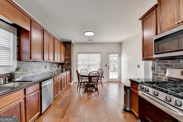 a view of a a dining room with furniture window and wooden floor