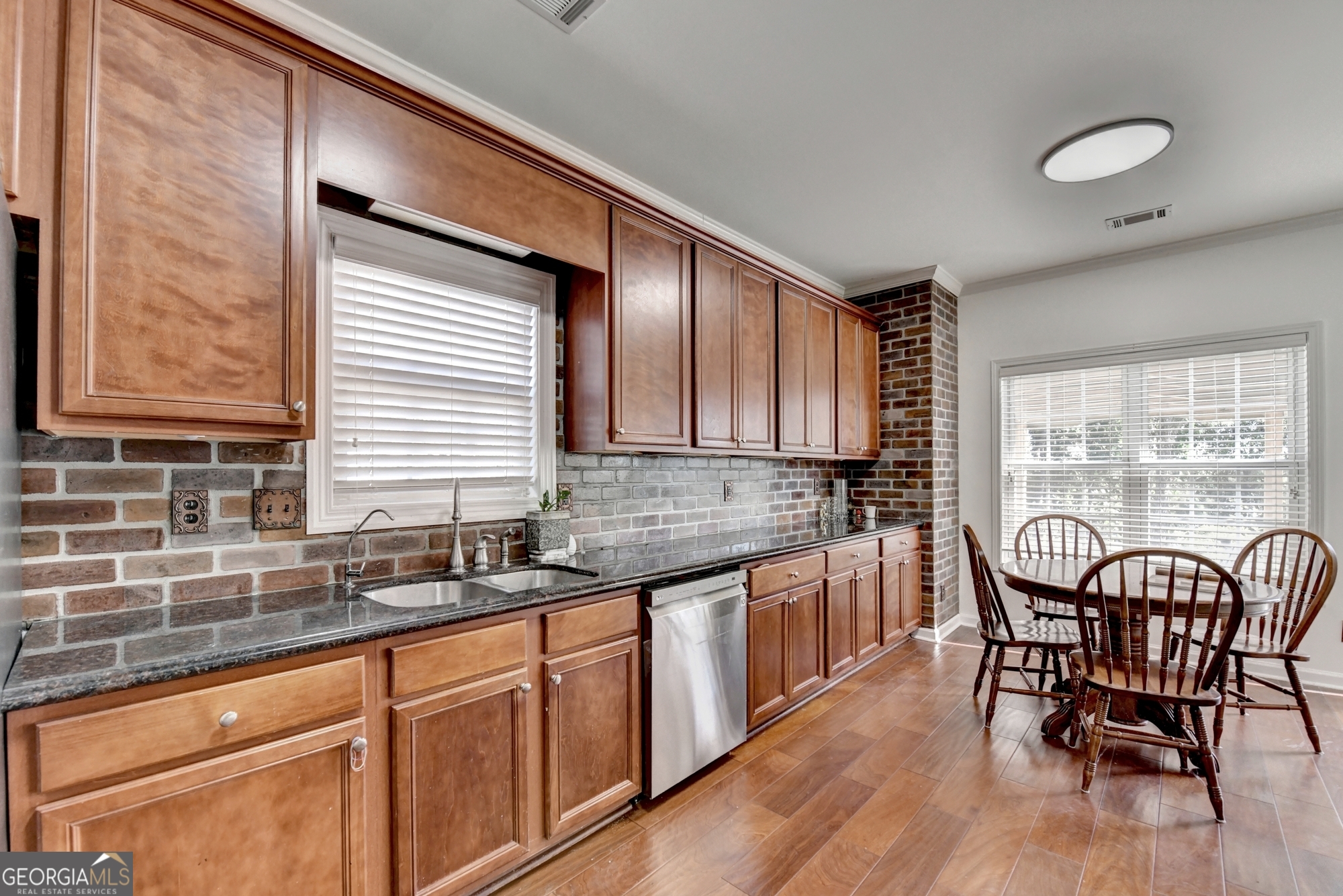 952 Cambron Cmns Trace Suwanee, GA 30024 - Photo 14 of 69 a kitchen with stainless steel appliances granite countertop wooden cabinets a table and chairs