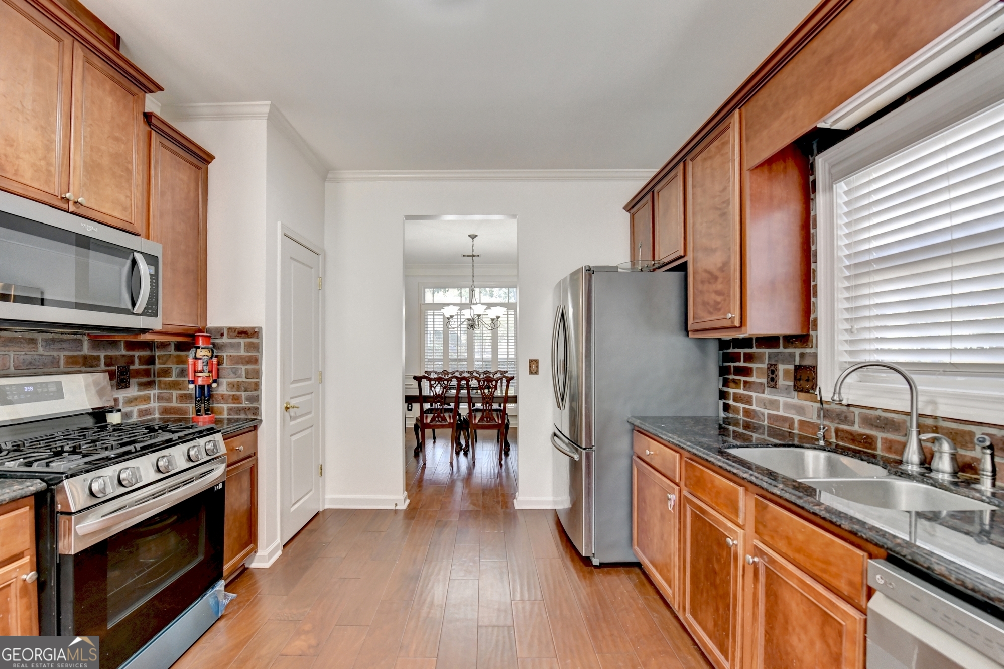 952 Cambron Cmns Trace Suwanee, GA 30024 - Photo 19 of 69 a kitchen with granite countertop a sink cabinets and stainless steel appliances