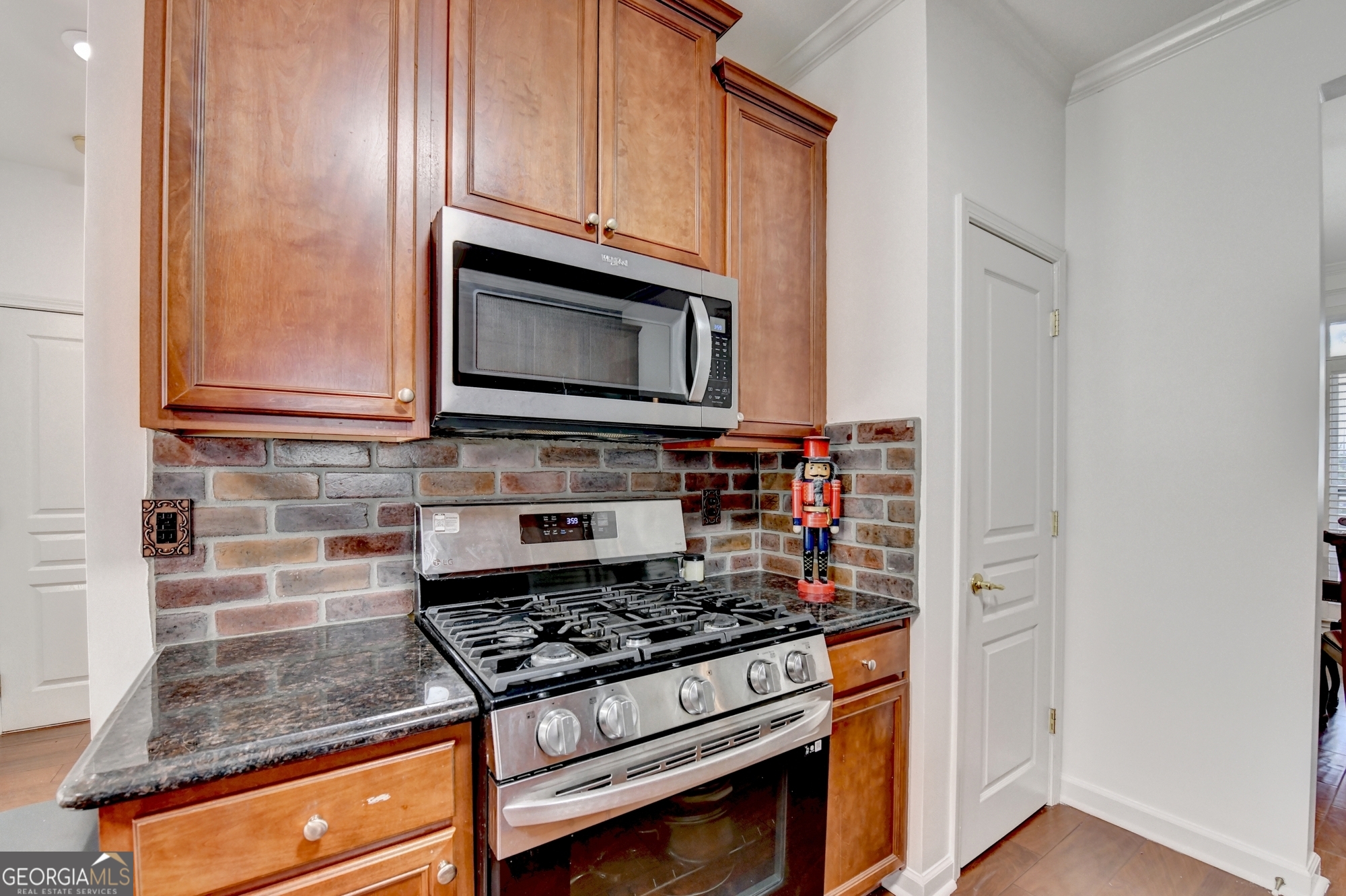 952 Cambron Cmns Trace Suwanee, GA 30024 - Photo 20 of 69 a kitchen with granite countertop cabinets stainless steel appliances and wooden floor