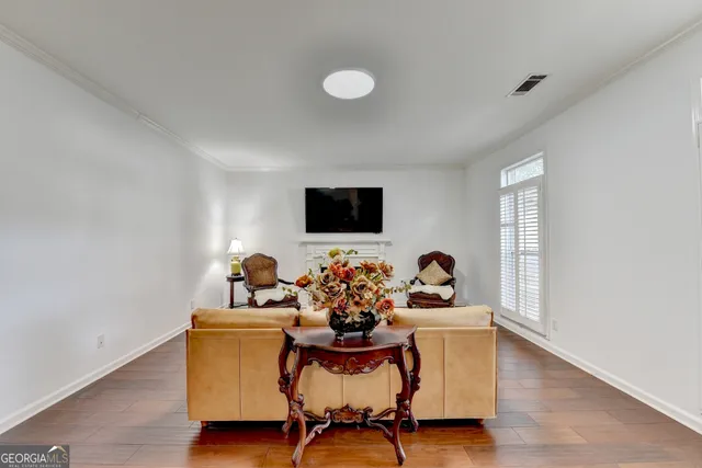 a living room with furniture piano and a potted plant