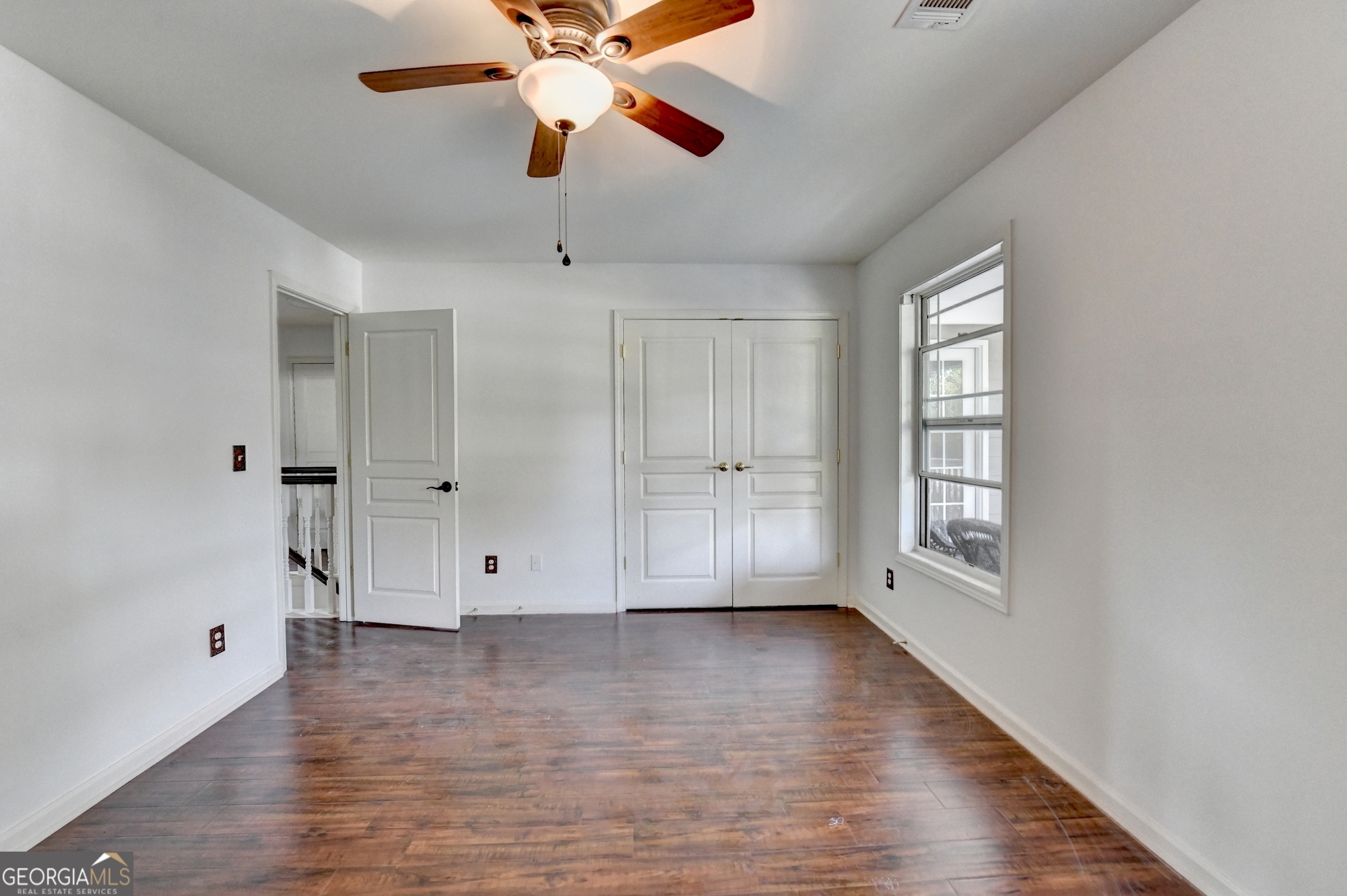 952 Cambron Cmns Trace Suwanee, GA 30024 - Photo 43 of 69 an empty room with wooden floor chandelier fan and windows