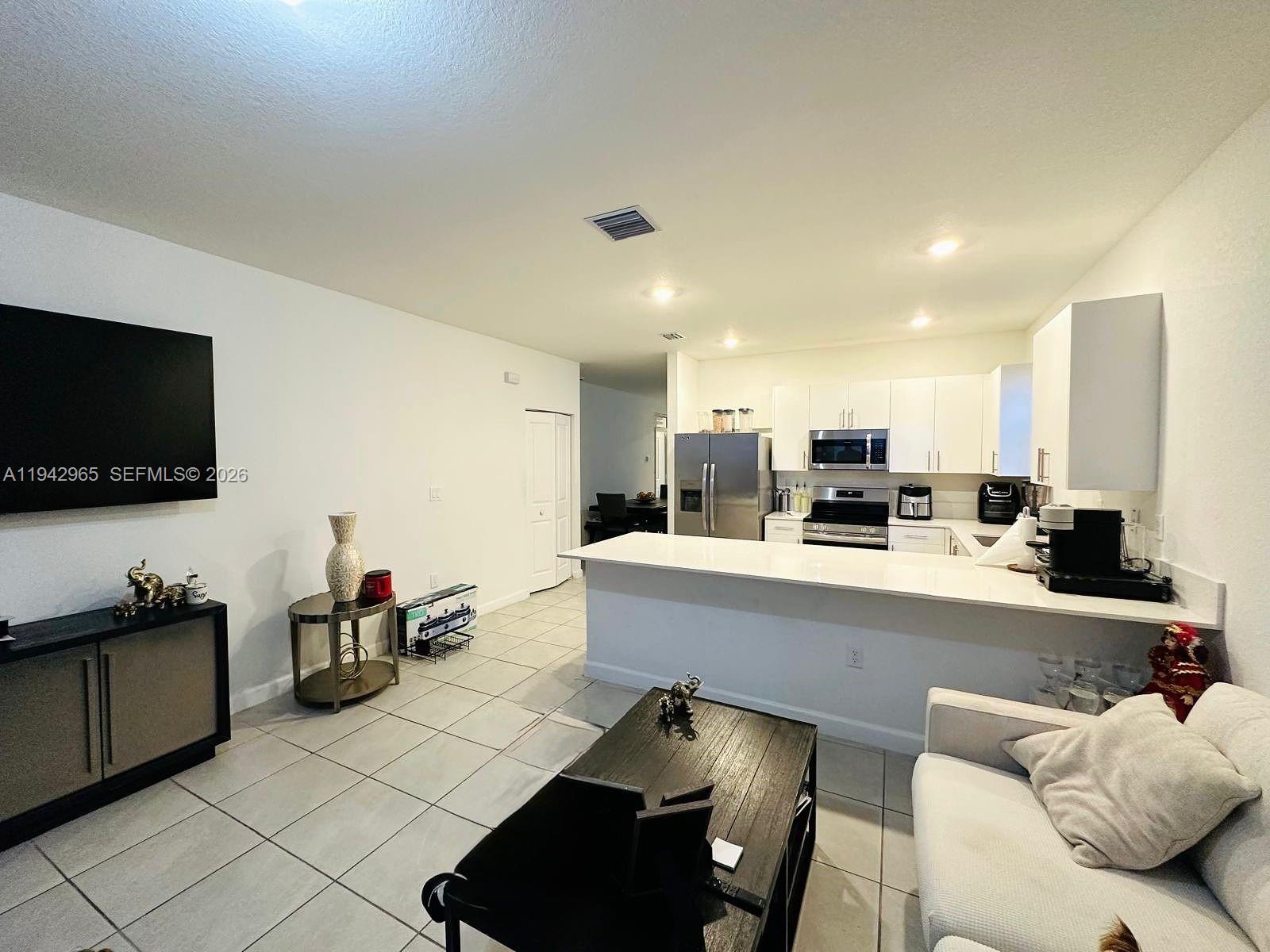 23357 Southwest 133rd Avenue Homestead, FL 33032 - Photo 8 of 14 a living room with stainless steel appliances furniture and a flat screen tv