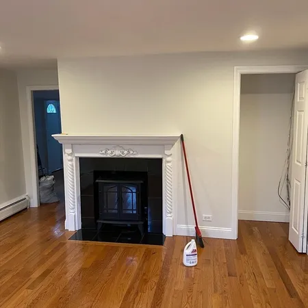 a living room with a fireplace and wooden floor