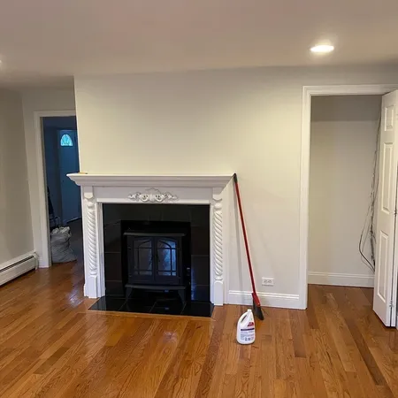 a living room with a fireplace and wooden floor
