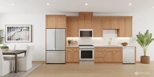 a kitchen with stainless steel appliances granite countertop a refrigerator a stove a sink and a microwave