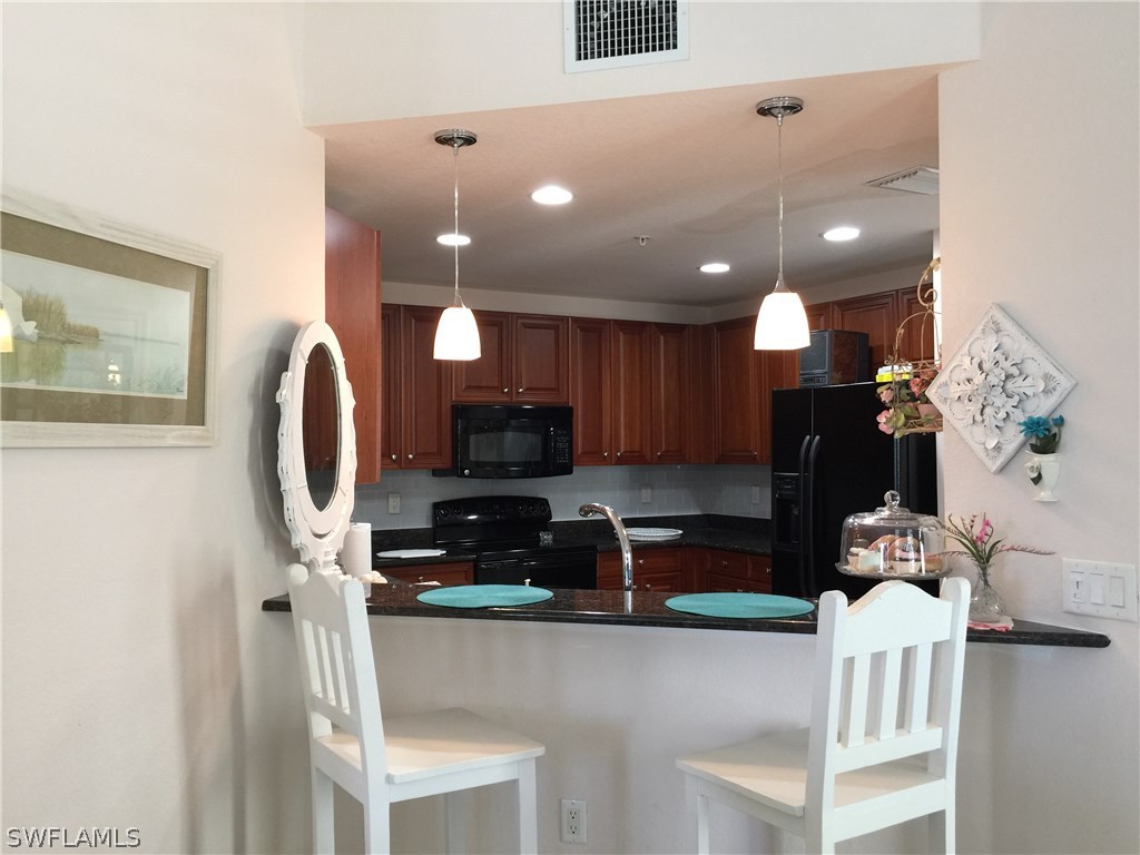 17210 Acapulco Road, Unit 211 Punta Gorda, FL 33955 - Photo 9 of 23 a kitchen with stainless steel appliances a refrigerator sink and cabinets