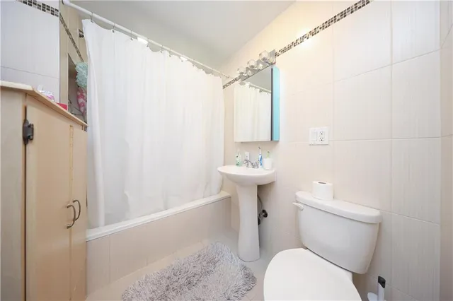 a white toilet sitting next to a bathroom sink