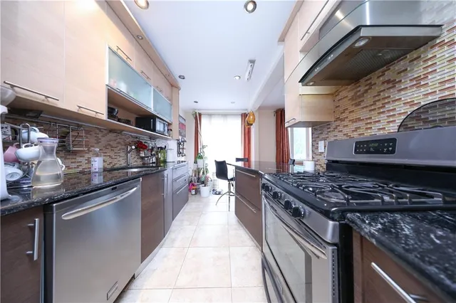 a kitchen with stainless steel appliances granite countertop a stove and a sink