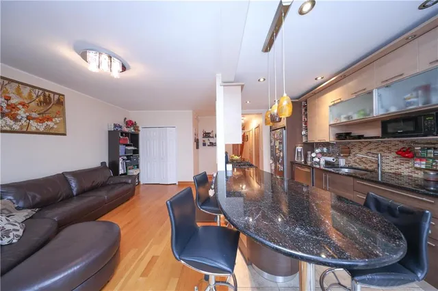 a living room with stainless steel appliances furniture a dining table and a fireplace