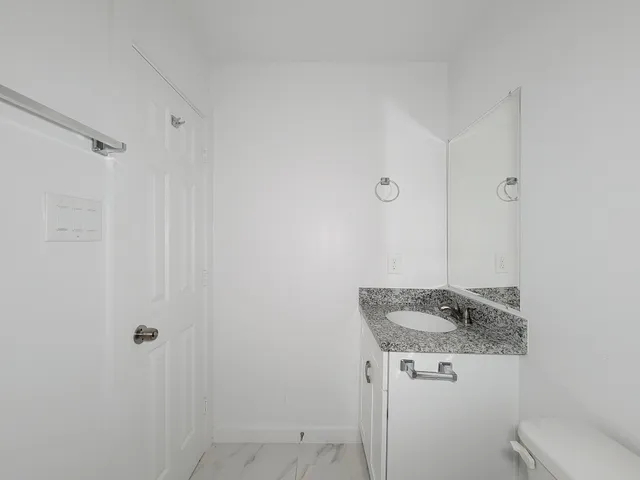 a bathroom with a granite countertop sink and mirror