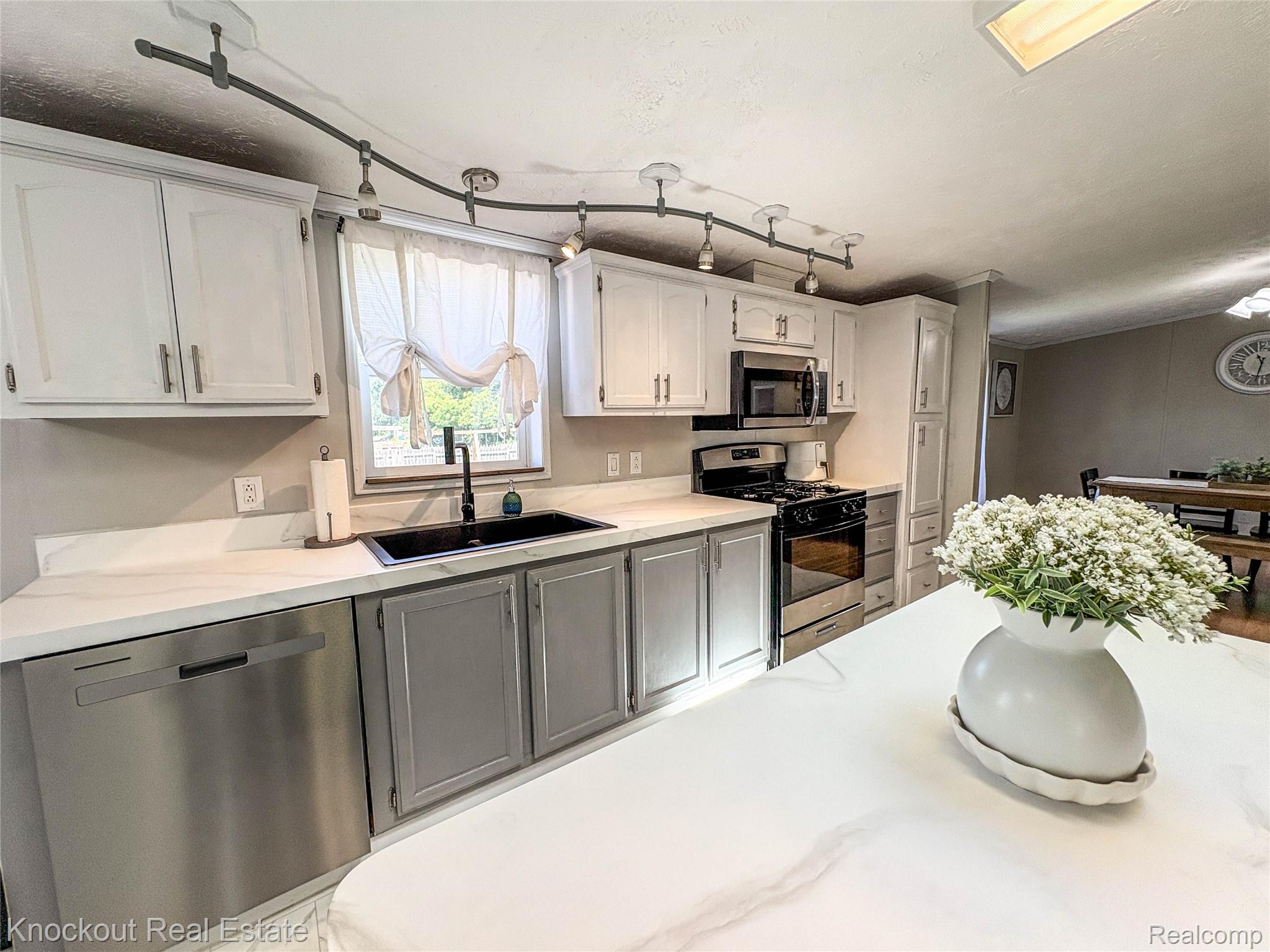 7760 Bell Road Birch Run, MI 48415 - Photo 19 of 68 Kitchen featuring white upper cabinetry, gray lower cabinetry, and stainless steel appliances