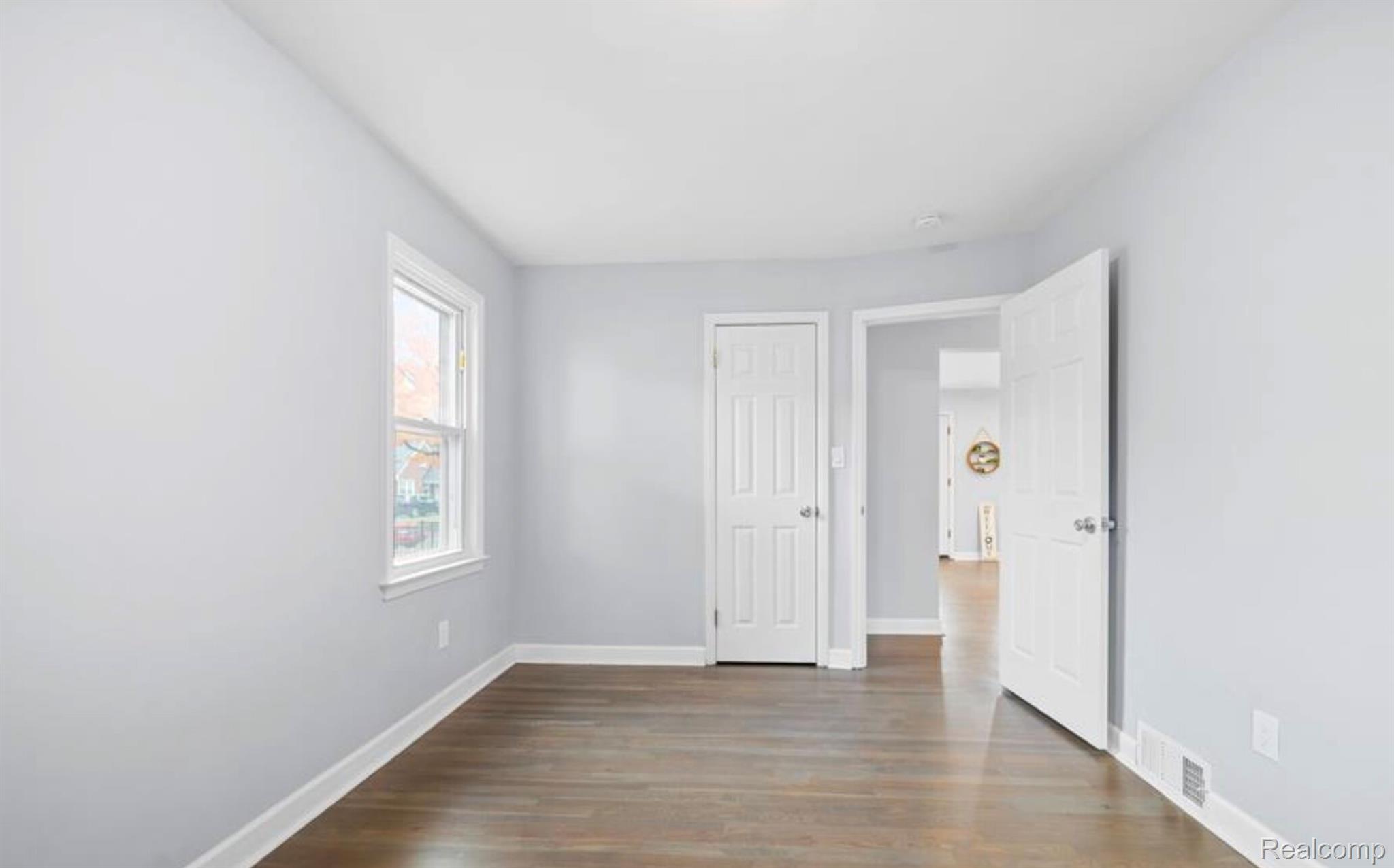 4214 Berkshire Road Royal Oak, MI 48073 - Photo 14 of 27 Light gray walls with white trim, wood-finish flooring, and a double-hung window
