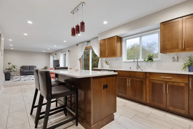 a kitchen with a dining table chairs sink and cabinets