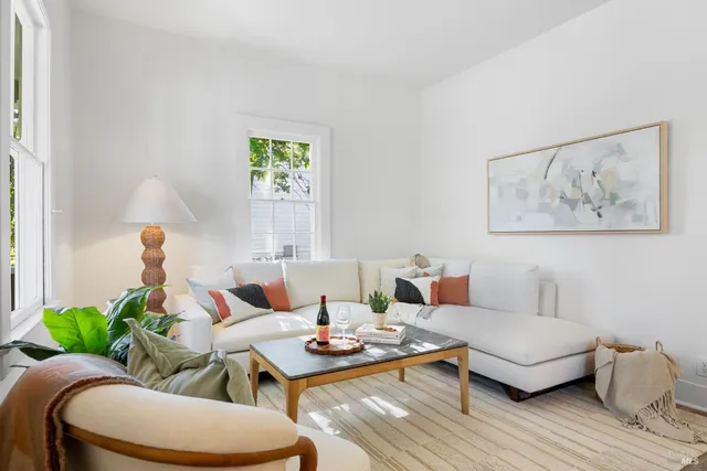 a living room with furniture a window and a potted plant