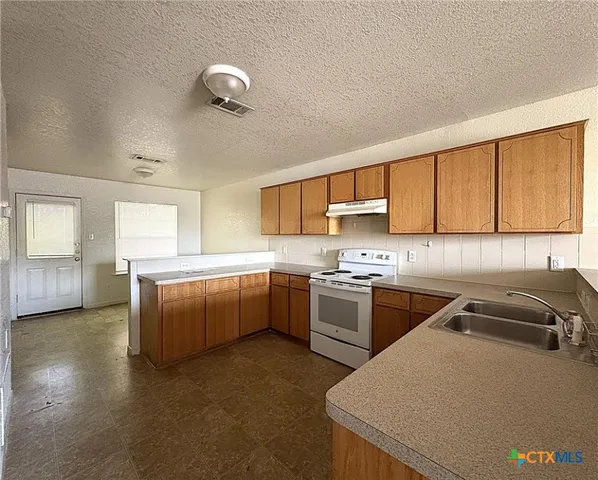 a kitchen with stainless steel appliances granite countertop a sink and cabinets