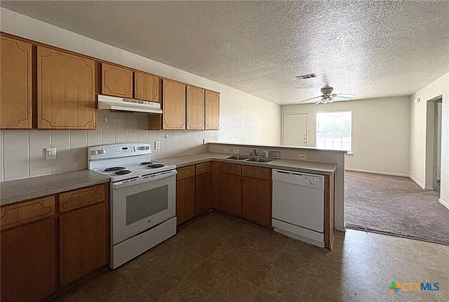 a kitchen with a sink stove and cabinets