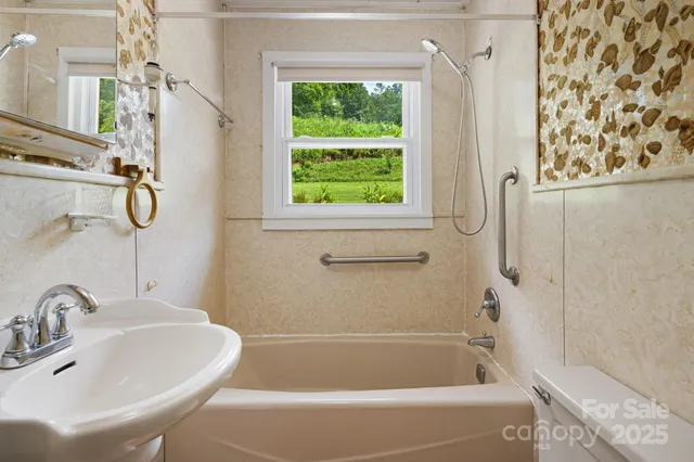 a bathroom with a sink a window and a shower