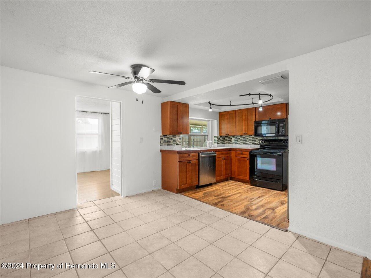 3902 Glissade Drive New Port Richey, FL 34652 - Photo 13 of 39 a kitchen with stainless steel appliances granite countertop a sink and cabinets