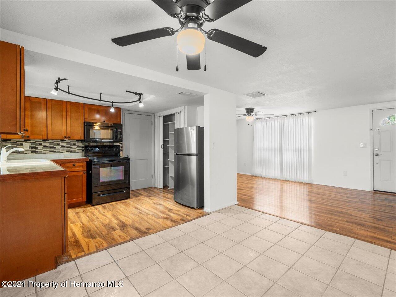 3902 Glissade Drive New Port Richey, FL 34652 - Photo 14 of 39 a kitchen with stainless steel appliances kitchen island granite countertop a refrigerator and a stove top oven