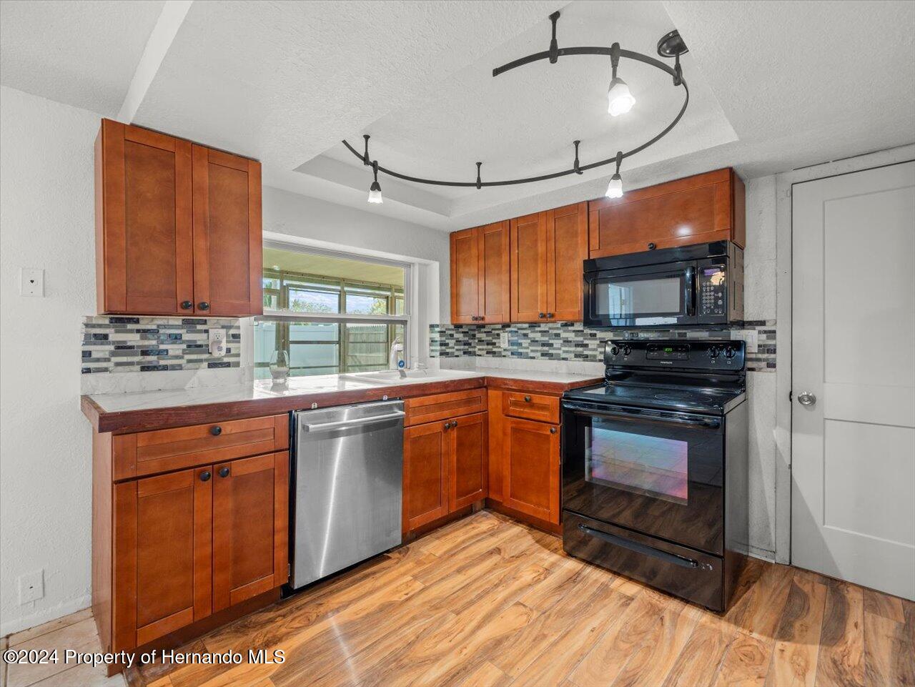 3902 Glissade Drive New Port Richey, FL 34652 - Photo 17 of 39 a kitchen with stainless steel appliances granite countertop a stove a sink and a microwave