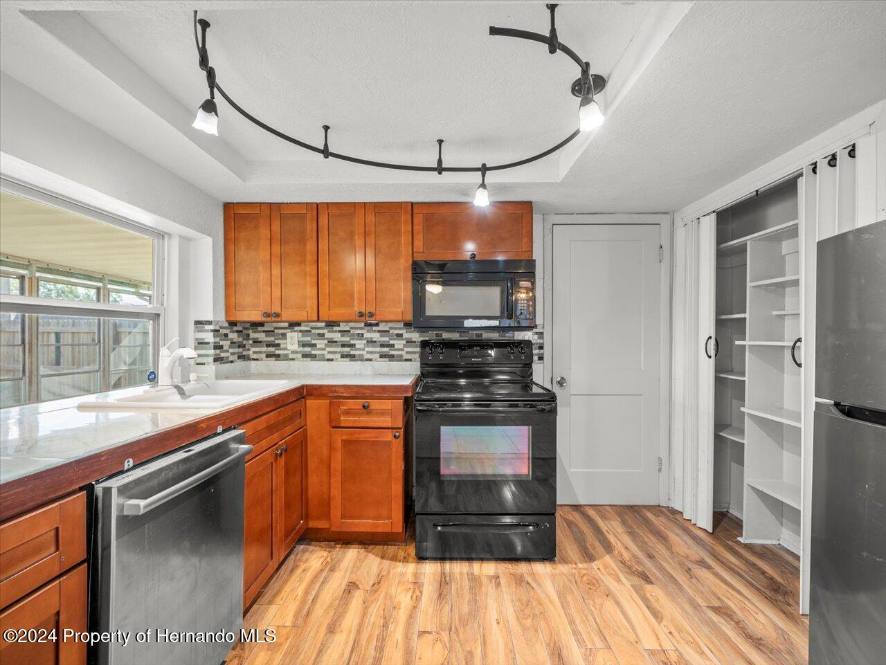 3902 Glissade Drive New Port Richey, FL 34652 - Photo 18 of 39 a kitchen with stainless steel appliances granite countertop a refrigerator and a sink
