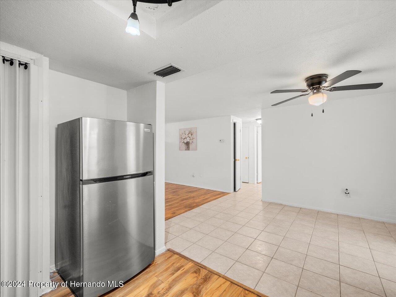 3902 Glissade Drive New Port Richey, FL 34652 - Photo 21 of 39 a view of a kitchen with a refrigerator and wooden floor