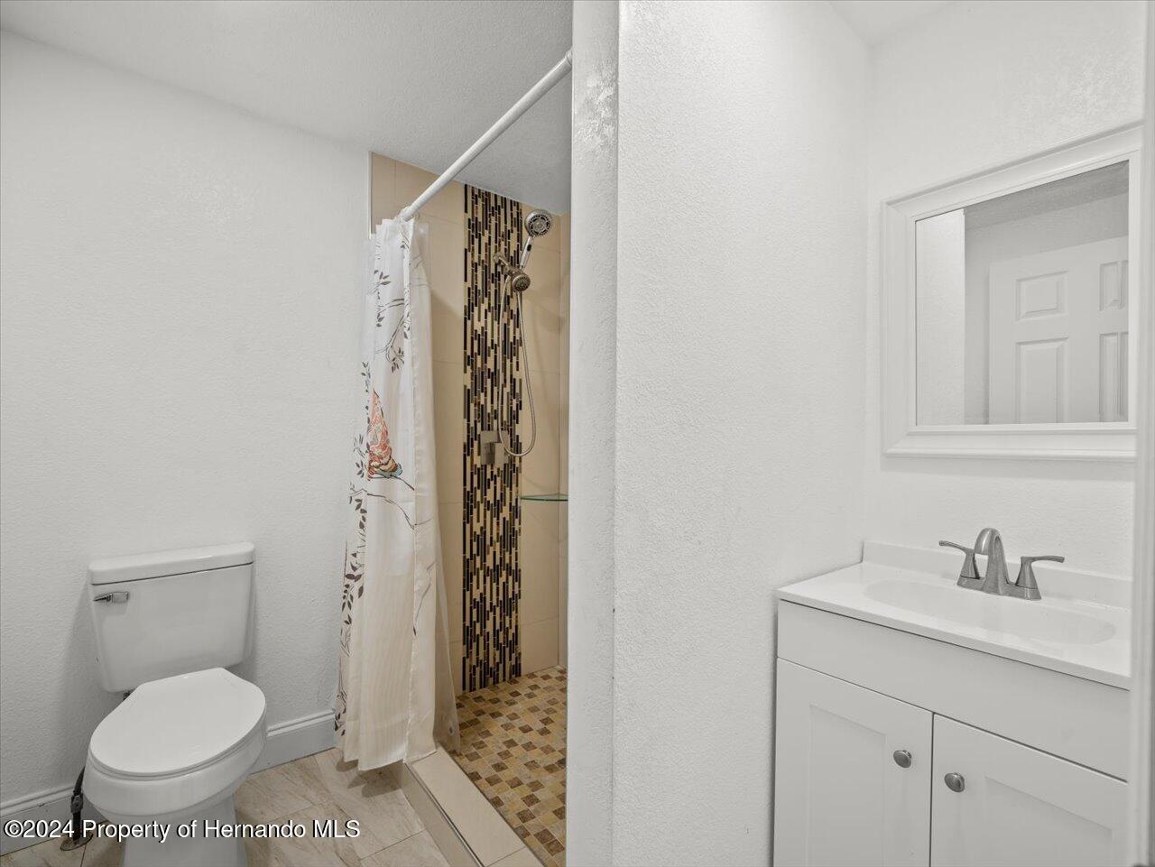 3902 Glissade Drive New Port Richey, FL 34652 - Photo 23 of 39 a bathroom with a granite countertop sink toilet and shower