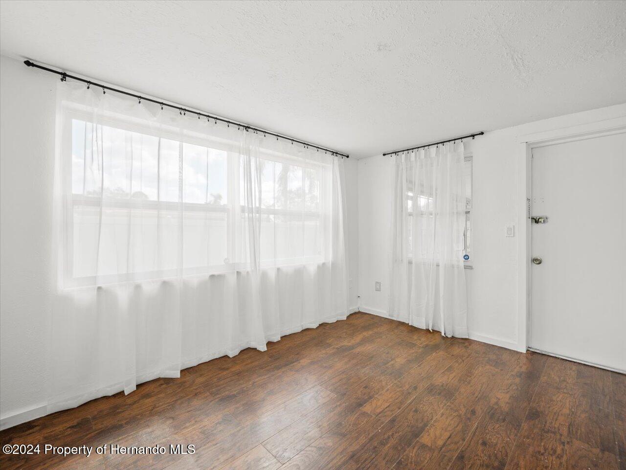 3902 Glissade Drive New Port Richey, FL 34652 - Photo 25 of 39 a view of an empty room with wooden floor and a window