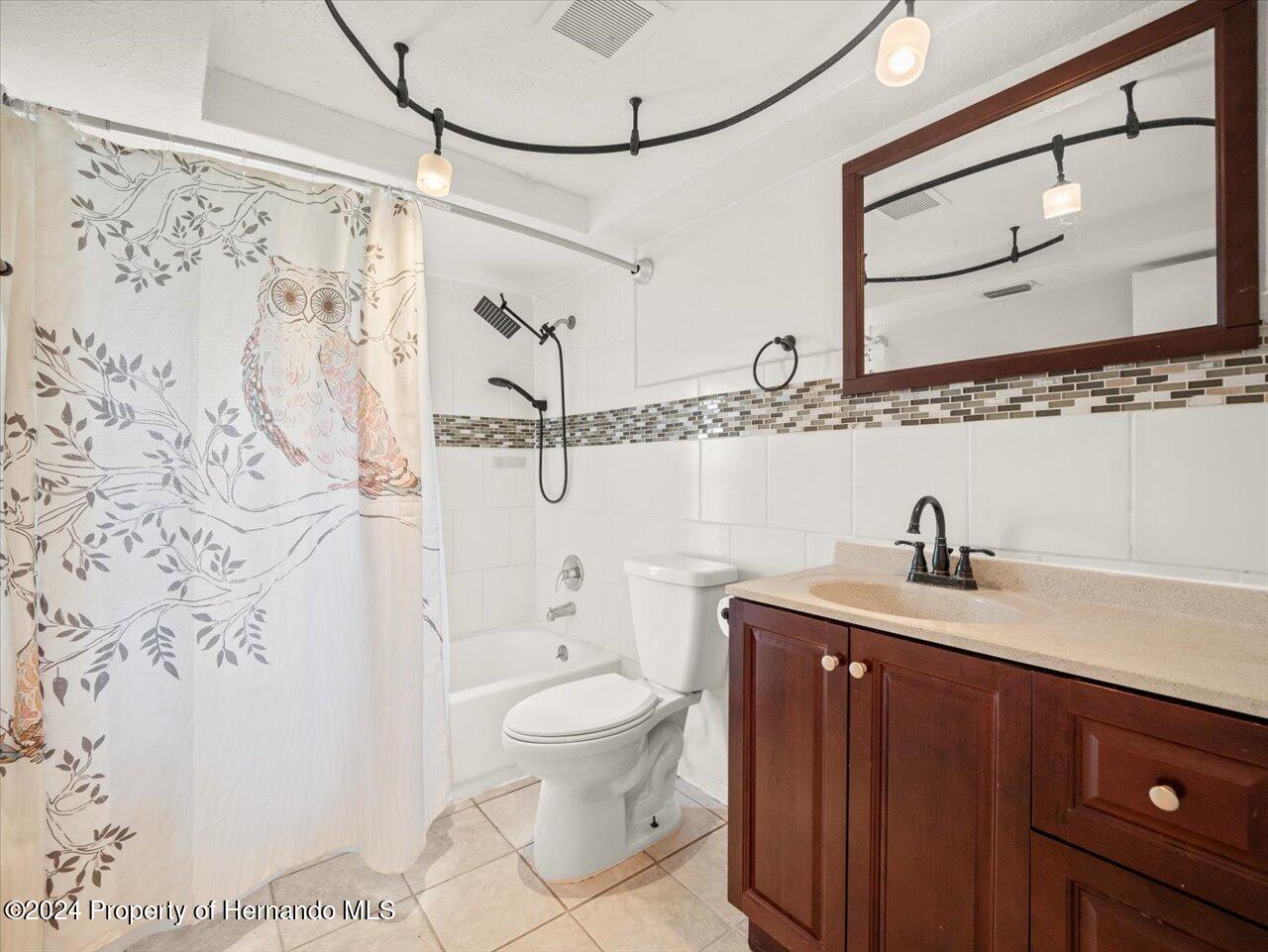 3902 Glissade Drive New Port Richey, FL 34652 - Photo 27 of 39 a bathroom with a granite countertop sink a toilet and a shower