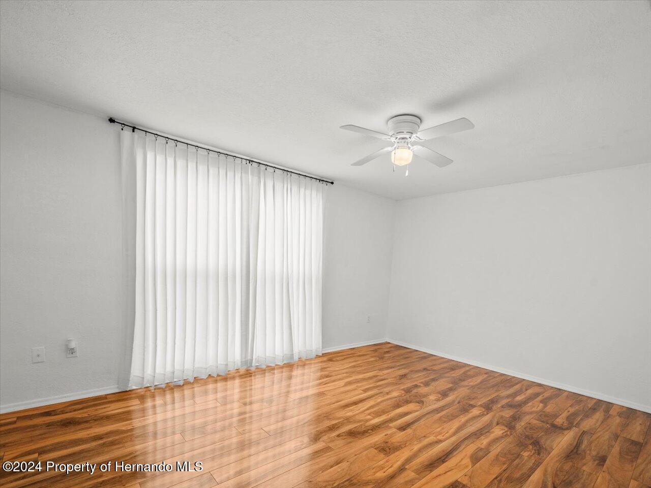 3902 Glissade Drive New Port Richey, FL 34652 - Photo 30 of 39 wooden floor in an empty room with a window