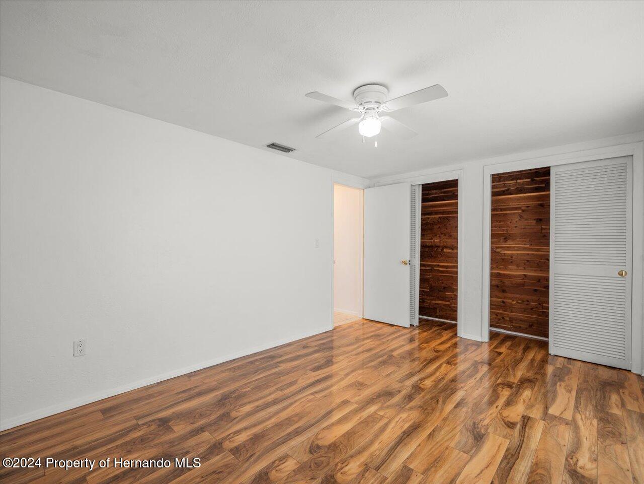 3902 Glissade Drive New Port Richey, FL 34652 - Photo 31 of 39 a view of empty room with wooden floor and fan