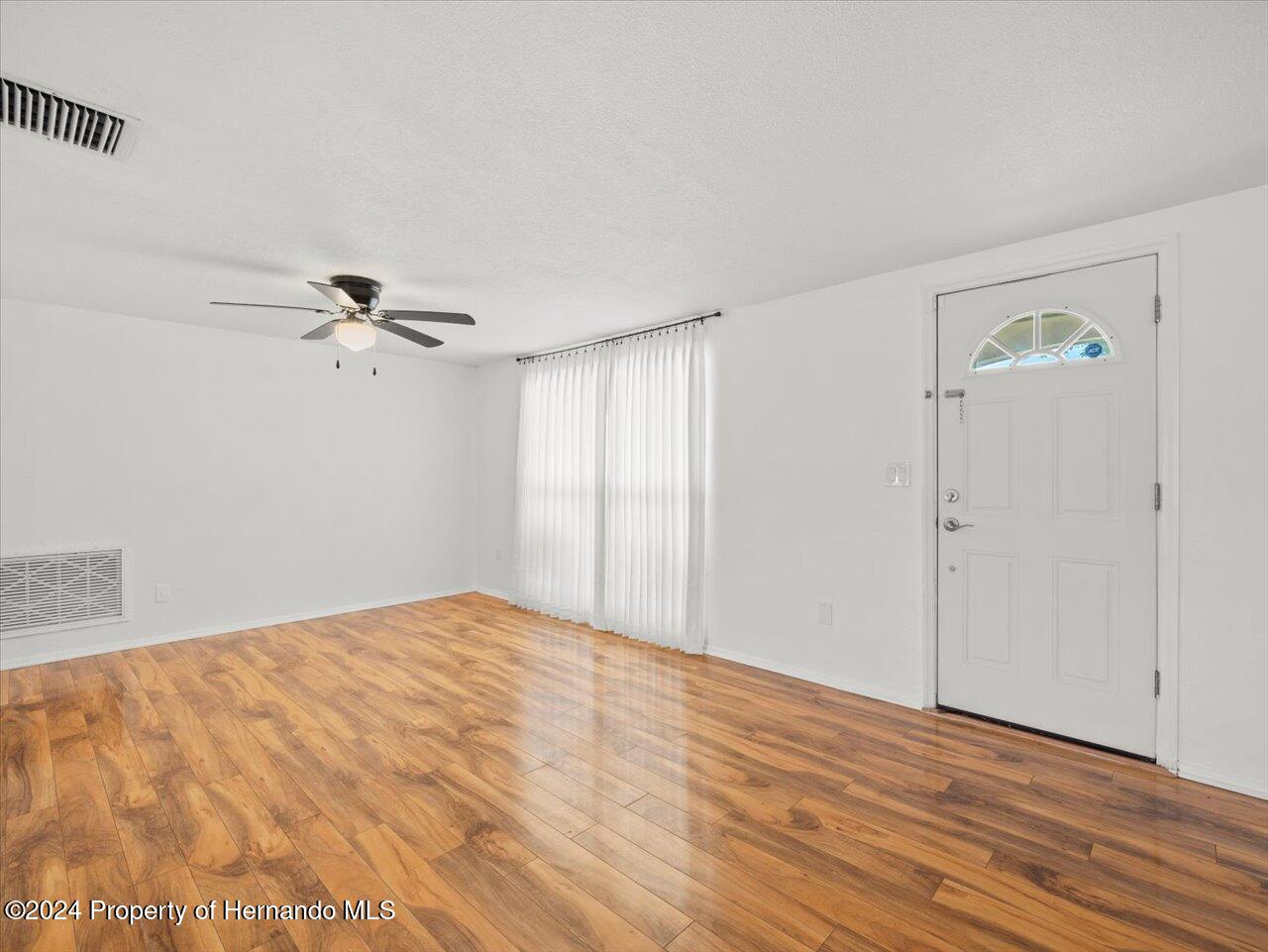 3902 Glissade Drive New Port Richey, FL 34652 - Photo 10 of 39 a view of empty room with wooden floor