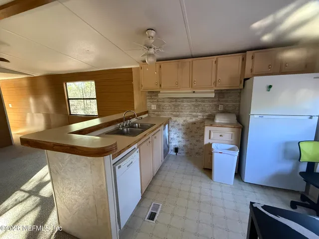 a kitchen with granite countertop a sink stove and refrigerator